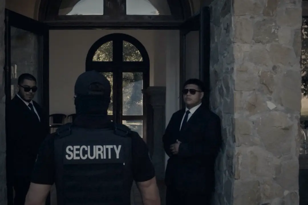 LDG security officer in a SECURITY vest between two agents at a venue entrance