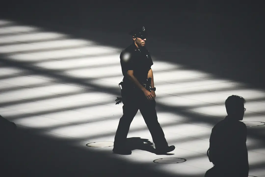 Off-duty police officer walking through shafts of light